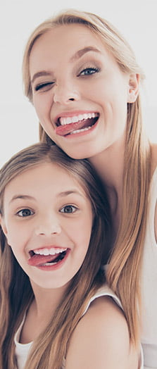 women and child smiling with their tongue out